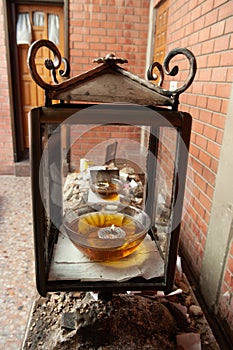 A glass bowl filled with oil and a candle sits inside a glass memorial at a Jewish gravesite in Jerusalem