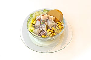 Glass bowl filled with Peruvian fish ceviche with cancha, sweet potato and lettuce photo