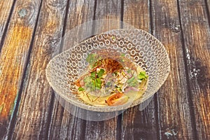 Glass bowl with fish ceviche with lots of coriander and saffron filaments