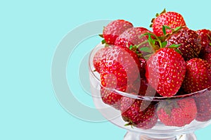 Glass bowl with fresh ripe strawberries, space for text, copy space isolated on blue background, layout, clipping