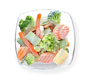 Glass bowl with frozen vegetables on white background