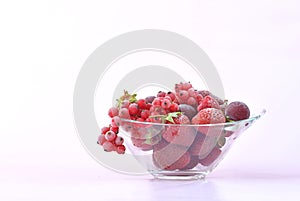 Glass bowl full of frozen red fruit