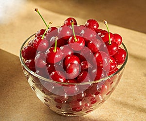 Glass bowl full of red ripe cherries