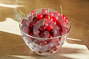 Glass bowl full of red ripe cherries