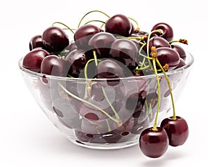 A glass bowl full with sweet cherries isolated