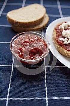 Glass bowl with homemade tomato sauce. Slices of wholemeal bread