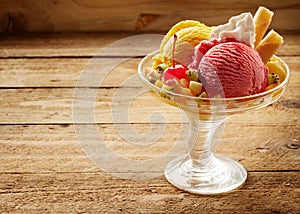 Glass bowl of ice cream on wooden surface