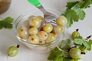 Glass bowl with marinated green gooseberries