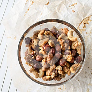 Glass bowl of mixed nuts on parchment paper and cooling rack