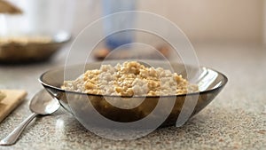 Glass bowl of oats porridge on the table. Healthy morning breakfast