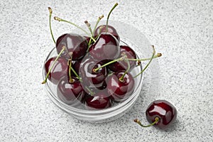 Glass bowl with red ripe juicy cherries