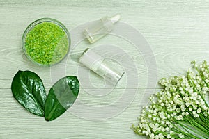 Glass bowl with sea salt, bottles with cream for face skin and a