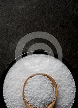 Glass Bowl of Sea Salt with Wooden Spoon with Copy Space Above