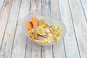 glass bowl with serving of Peruvian fish ceviche with avocado, corn, lime and sweet potato