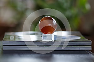Glass ball on a stack of magazines