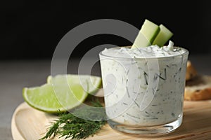 Glass bowl of Tzatziki cucumber sauce on wooden board