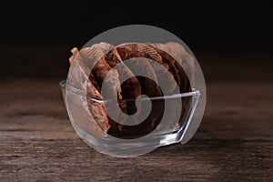 Glass bowl with used tea bags on wooden table