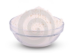 Glass bowl of wheat flour isolated on white background