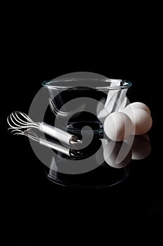 Glass bowl whisker eggs side view with reflection vertical black