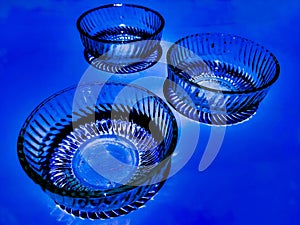 Glass bowls isolated in blue background.