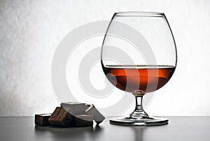 Glass of brandy and chocolate pieces