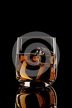 In a glass of brandy with ice on a black background