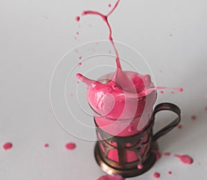 a glass with a bright liquid and flying splashes