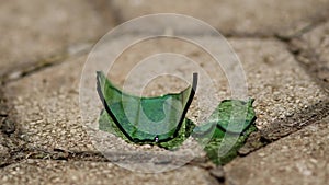 Glass from a broken bottle. Summer sunny day. A piece of green glass swings