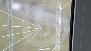 Glass broken by hooligans in a metal-plastic window, close-up