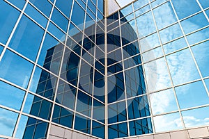 Glass building with mirrored windows. Skyscraper. Line pattern, perspective, steel structure, urban abstraction. Geometric shape,