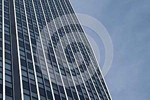 Glass building office lines reflect the cloudy sky