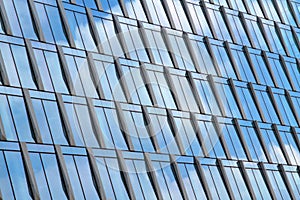 GLASS BUILDING WITH WINDOWS AN REFLECTIONS OF SKY AN CLOUDS