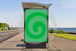 glass bus stop by the sea, with a chroma key advertising space. Blank billboard and outdoor advertising. Mockup poster
