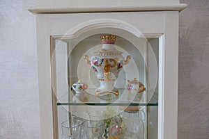 Glass cabinet with ceramic teapot, samovar
