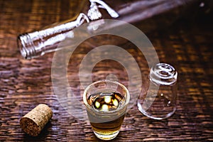 Glass of cachaÃÂ§a, in a rustic setting. CachaÃÂ§a or pinga, Brazilian drink from sugar cane. Rustic bar setting, Brazilian still