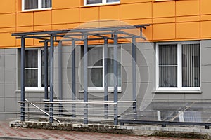 Glass canopy to protect from precipitation at the entrance to a modern office building