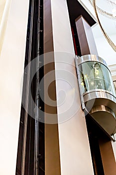 Glass capsule elevator in the hall at luxury hotel