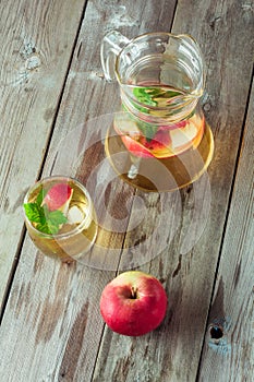 Glass and carafe of green tea with mint and apples