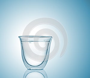 Glass with carbonated water on blue gradient background