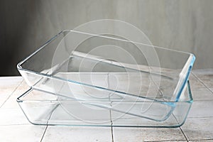 Glass casseroles on light tiled table, closeup