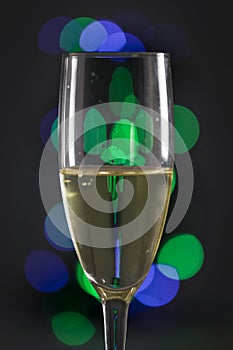 Glass of cava with colored lights in the background