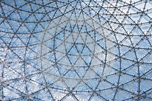 Glass ceiling in blue sky sunlight, abstract. Glass roof of the building. Geometrical ceiling, limpid round ceiling