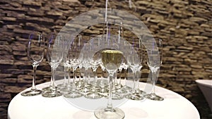 A glass of champagne on the background of empty glasses, on the buffet table, Champagne foam in a glass, camera movement