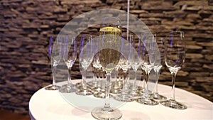 A glass of champagne on the background of empty glasses, on the buffet table, Champagne foam in a glass, camera movement