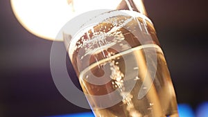 Glass with champagne by nightclub lights on blue background