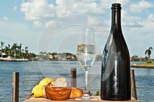 Glass of champagne with pear and bread and vintage bottle