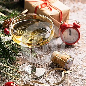 A glass of champagne sparkling wine cork clock close-up on a festive decorated table. Christmas New Year concept.