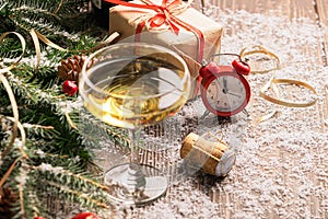 A glass of champagne sparkling wine cork clock close-up on a festive decorated table. Christmas New Year concept.