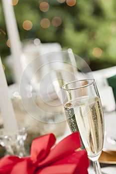Glass of Champagne on Table Place Setting and Christmas Gift