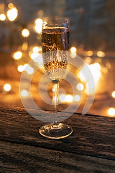A glass of champagne on a wooden background.Bubbly. A goblet of Sparkling wine. A wineglass of Fizz